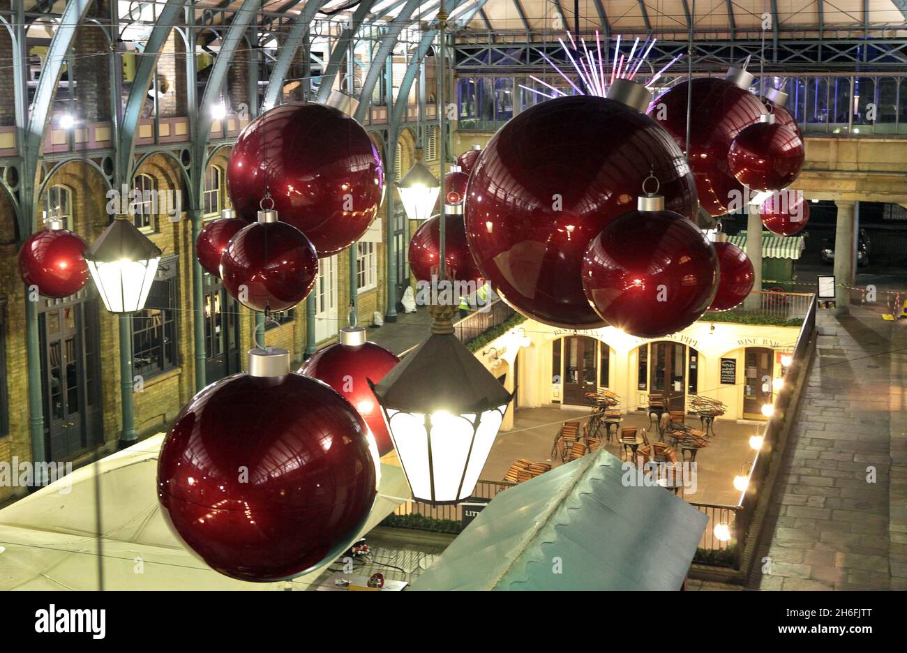 I lavoratori si adoperano per tutta la notte per preparare baubles giganti che saranno appesi al tetto dell'iconico Market Building, Covent Garden, come parte delle celebrazioni del 'Merry Kissma'. Un albero gigante di 50 piedi, completo di un display interattivo di illuminazione chiamato Ã¢'The KISS', decorerà anche la Piazza. L'albero, che contiene 50,000 luci a LED, si illuminerà quando due persone baciano sotto di loro. Una serie gratuita di attività ed eventi, che includono la renna accarezzare, inizia il prossimo Giovedi 11 con un ospite speciale celebrità. Per ulteriori informazioni, visitare il sito Web www.coventgardenlondonuk.com Foto Stock