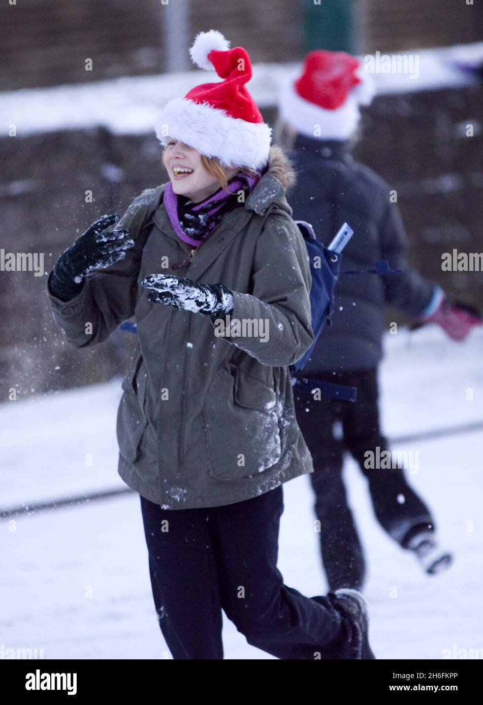 PRODOTTO ALTERNATIVO. Gli alunni della scuola elementare George Tomlinson di Leytonstone, Londra, festeggiano nella neve mentre si rompono per le vacanze di Natale. Foto Stock