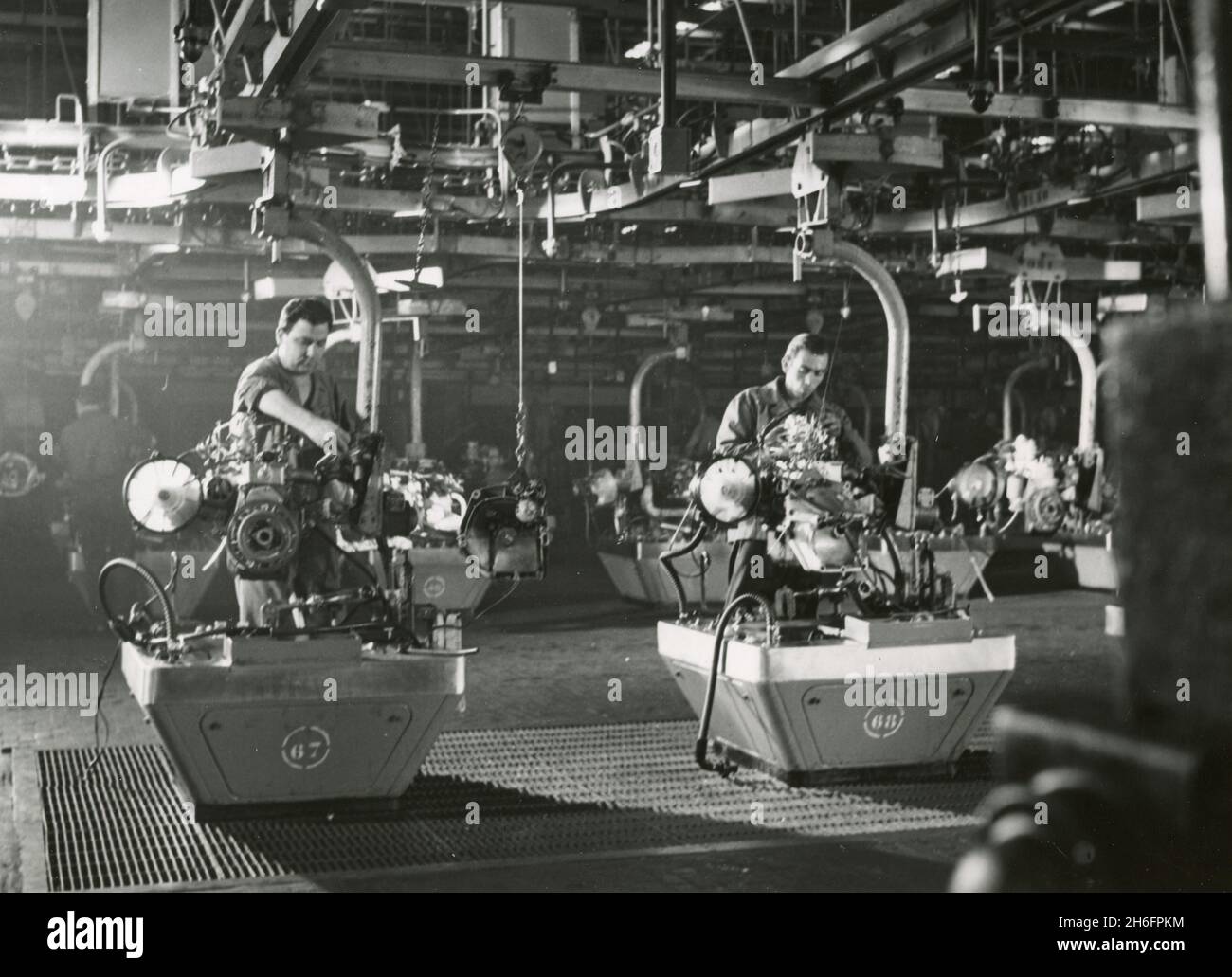 Lavoratori che controllano le caratteristiche dei motori completamente assemblati presso la fabbrica FIAT di automobili, Mirafiori, Italia anni '60 Foto Stock