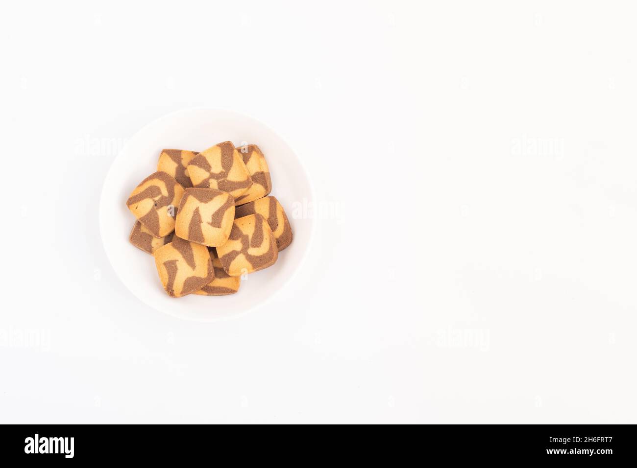 Biscotti marroni a forma quadrata con gocce di cioccolato serviti in un piatto bianco. Vista superiore sovrapposizione flay su sfondo bianco con spazio di copia per testo personalizzato Foto Stock