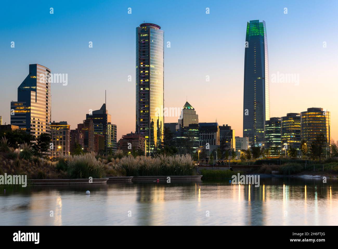 Laghetto presso il Parco del Bicentenario nel benestante quartiere Vitacura e sullo skyline di edifici al quartiere finanziario di Santiago del Cile Foto Stock