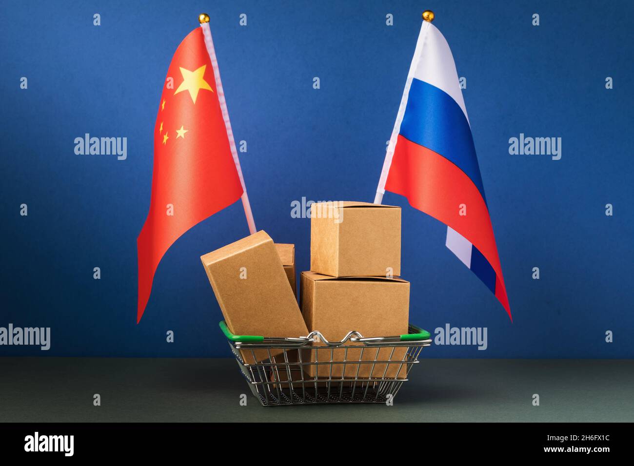 Varie scatole in un cestino di cibo e due bandiere su sfondo blu, il concetto di commercio tra Cina e Russia Foto Stock