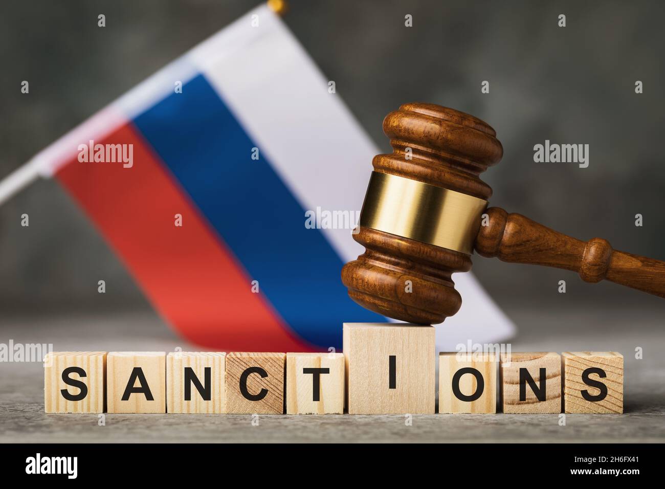 Gavel del giudice, cubi di legno con il testo sullo sfondo della bandiera russa, il concetto sul tema delle sanzioni in Russia Foto Stock
