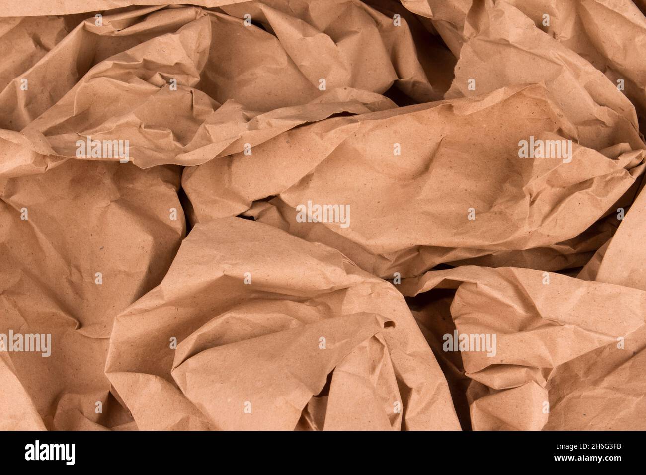 Sfondo ecologico realizzato con carta riciclata sgualcita con spazio per la copia del testo, per la presentazione o il sito Web. Riempitivo per carta. Artigianato marrone Foto Stock