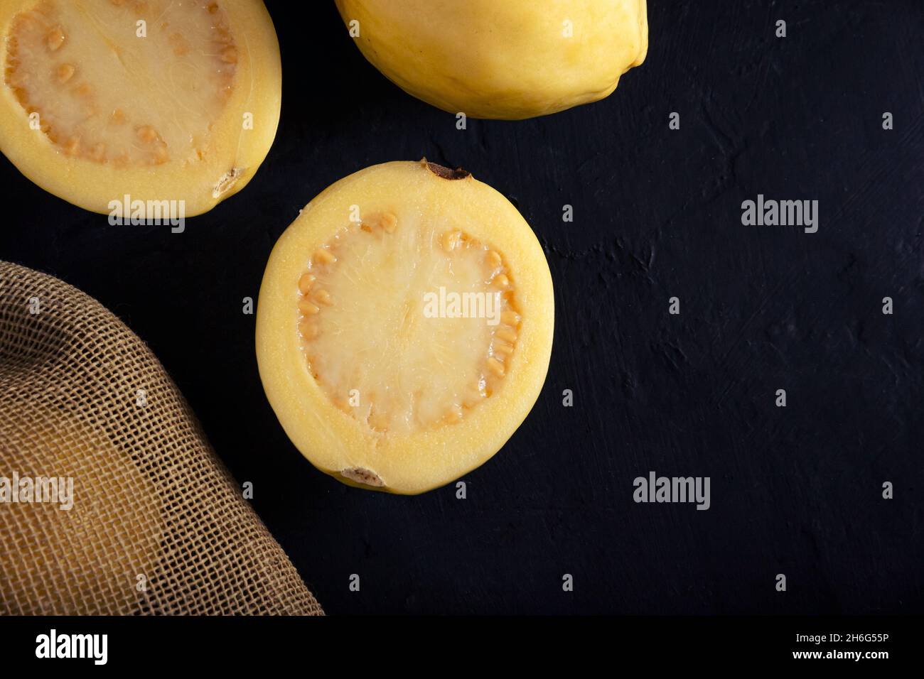 Guava gialla su sfondo nero, stile di vita tranquillo. Dieta sana Foto Stock