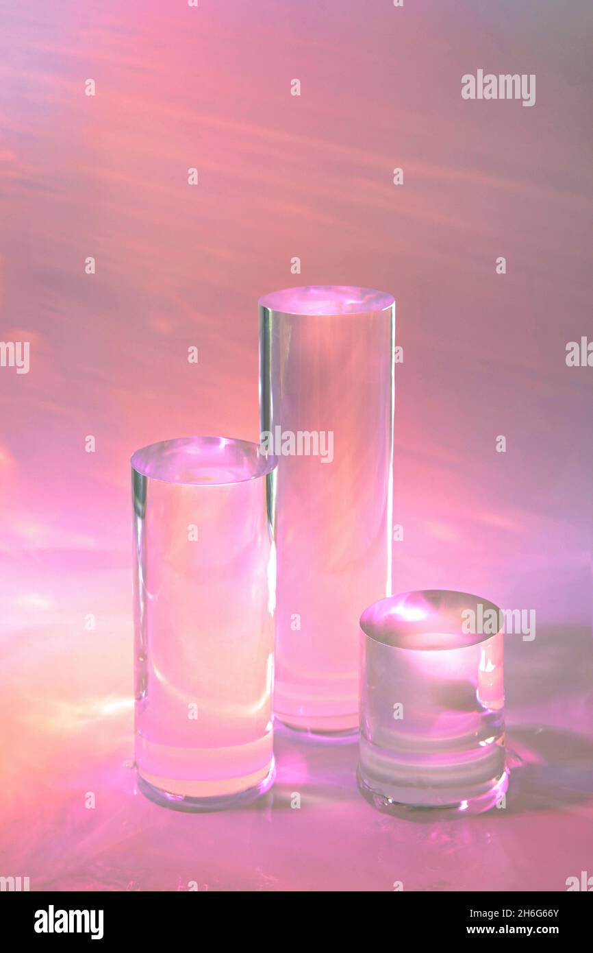 tre podi in vetro chiaro su sfondo rosa pastello Foto Stock