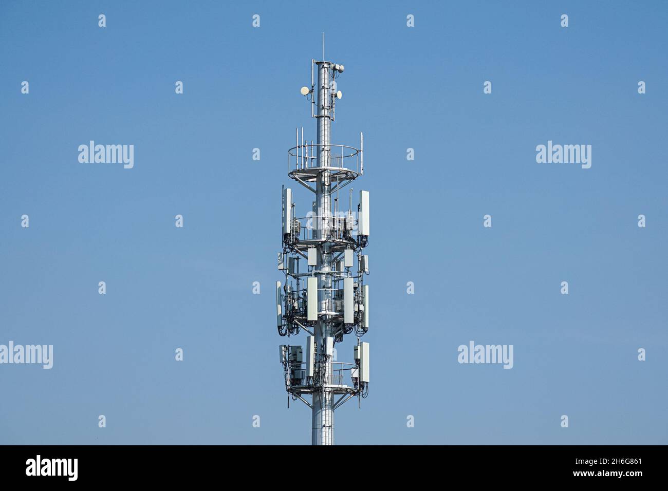 Cellulare, cellulare torre di telecomunicazione con antenne su cielo blu Foto Stock