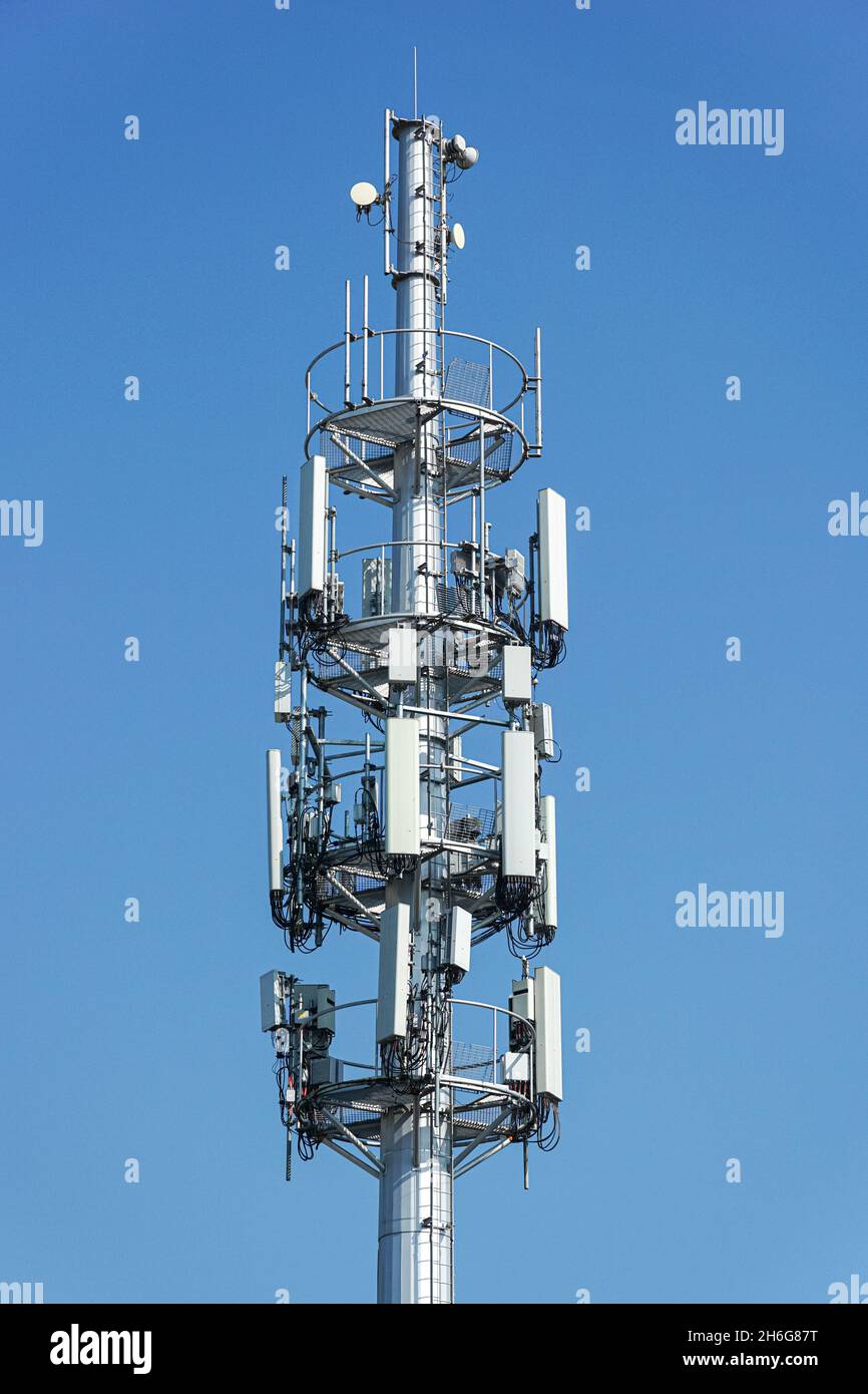 Cellulare, cellulare torre di telecomunicazione con antenne su cielo blu Foto Stock