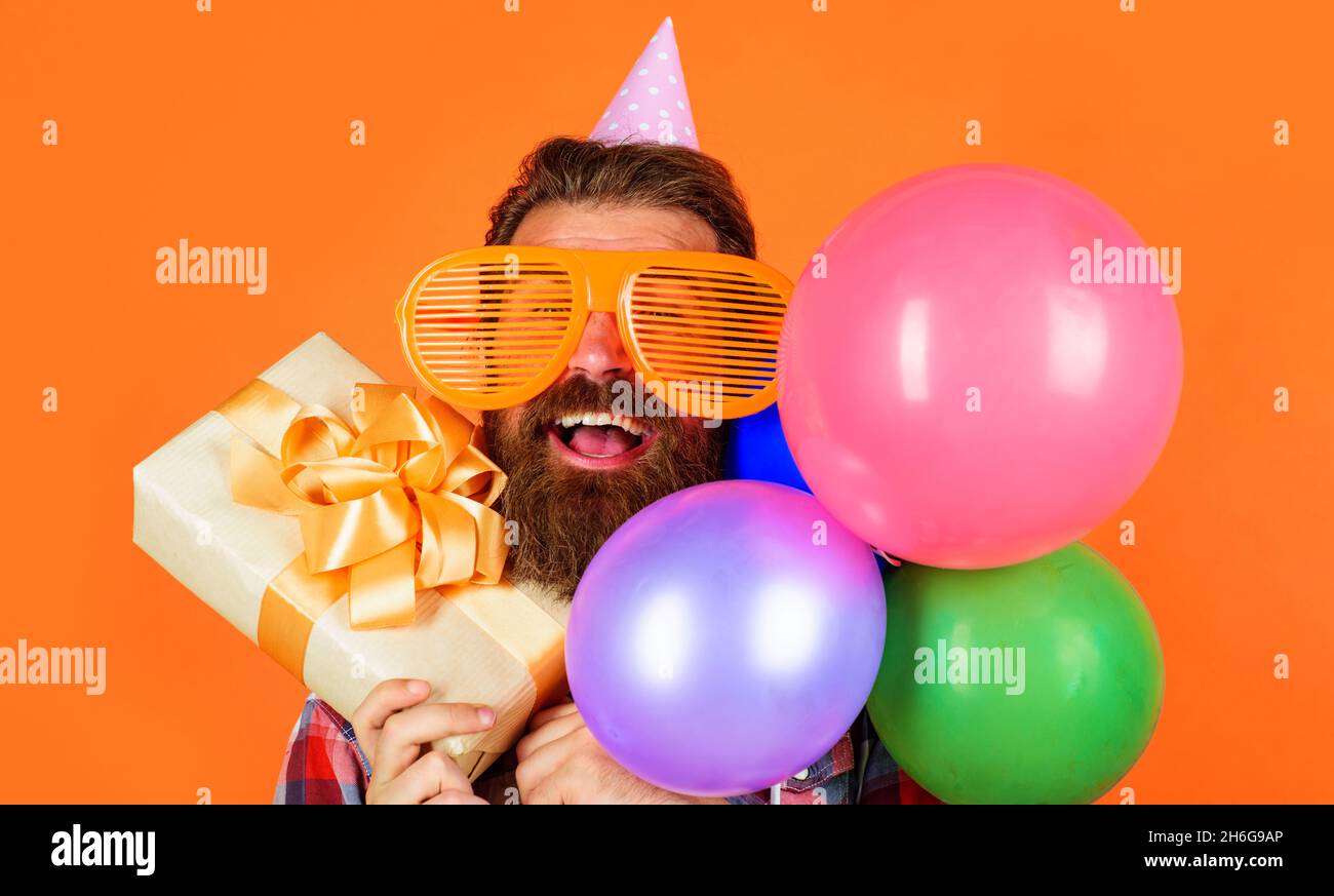 Felice uomo Bearded con scatola presente e palloncini. Buon compleanno, vacanze, festa, festa Foto Stock