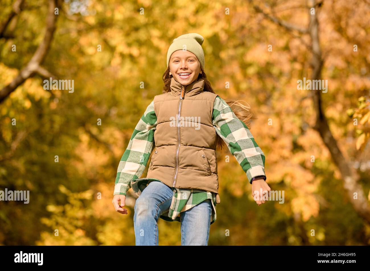 Una ragazza in abiti caldi che gioca nel parco Foto Stock