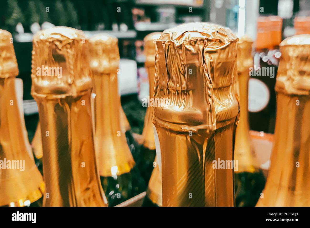 Ci sono un sacco di bottiglie di champagne in negozio. Vendita di bevande alcoliche prima della vacanza. Primo piano dei colli di bottiglia. Foto Stock