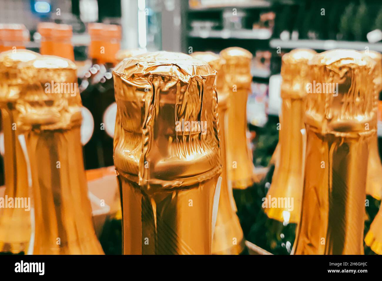 Ci sono un sacco di bottiglie di champagne in negozio. Vendita di bevande alcoliche prima della vacanza. Primo piano dei colli di bottiglia. Foto Stock