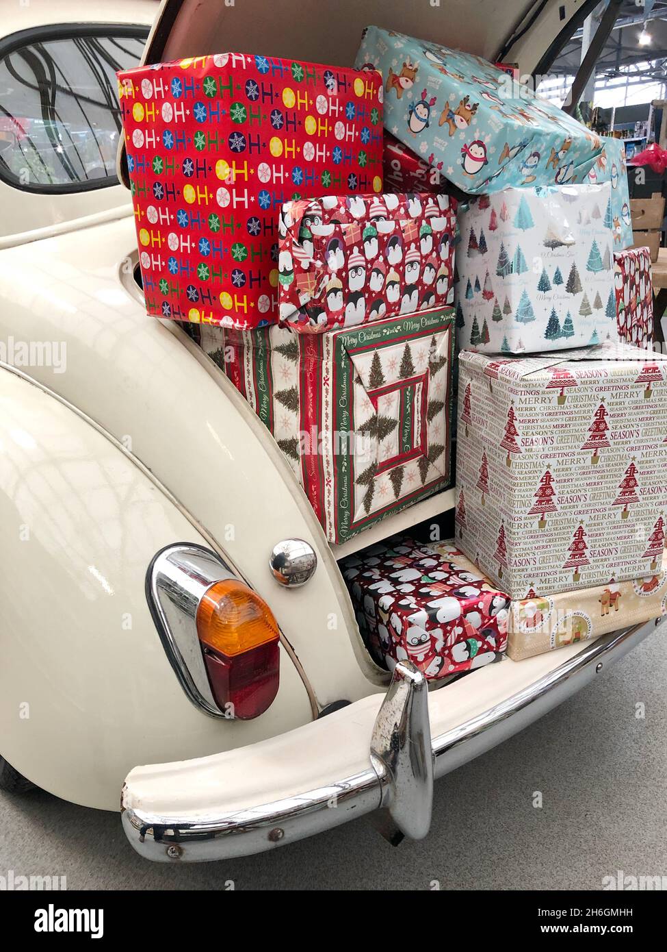 Una scarpa per auto piena di regali di Natale in carta da imballaggio colorata pronta per la consegna Foto Stock