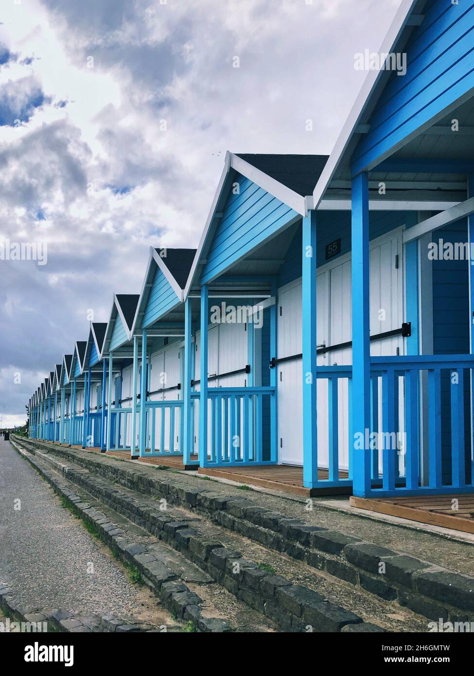 Una fila di belle capanne blu sulla spiaggia nella tradizionale cittadina marittima britannica di Bridlington Foto Stock
