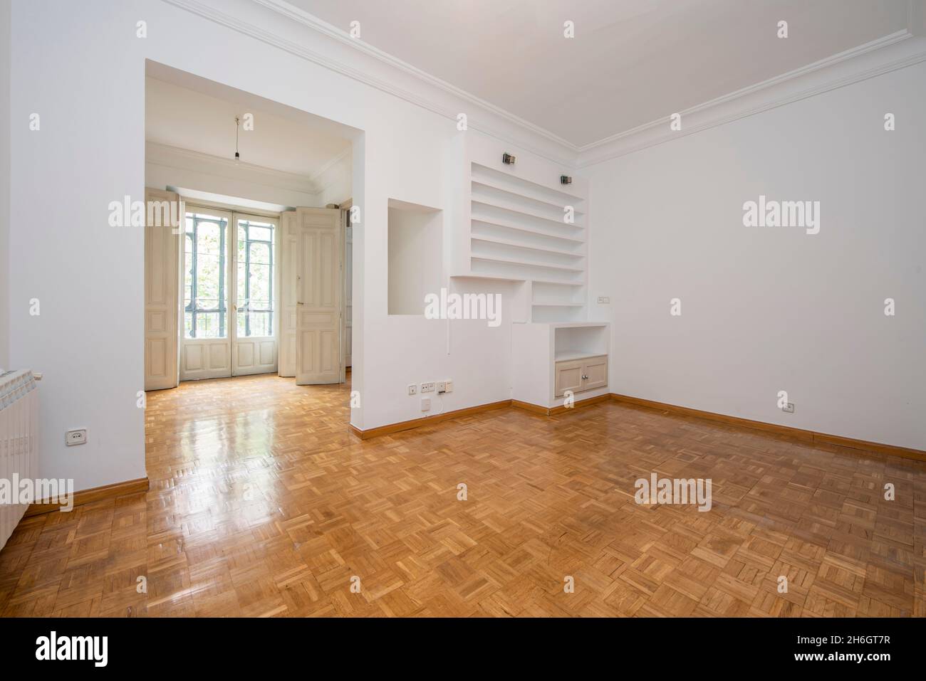 Soggiorno vintage e finestra a golfo con scaffali in gesso dipinto di bianco in un appartamento per vacanze Foto Stock