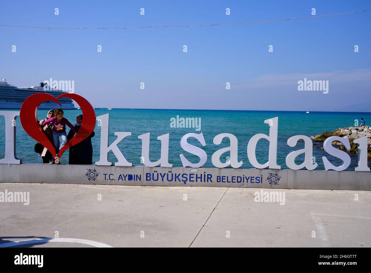 Famiglia in posa con il segno i Love Kusadasi a Kusadasi, Turchia Foto Stock