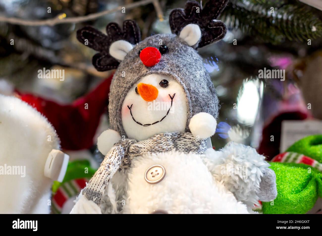 Uomo di neve giocattolo brillante e colorato sullo scaffale nel negozio. Natale e Capodanno concetto. Foto Stock