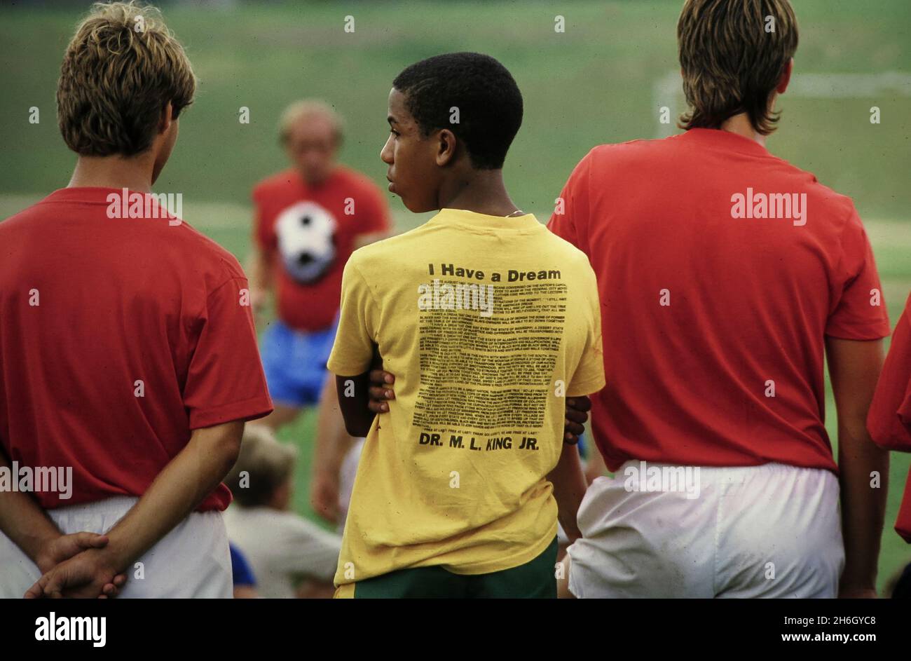 Austin Texas USA, circa 1986: Il discorso di Martin Luther King Jr. 'I Have a Dream' stampato sul retro di una T-shirt su un ragazzo nero al campo di calcio. ©Bob Daemmrich Foto Stock