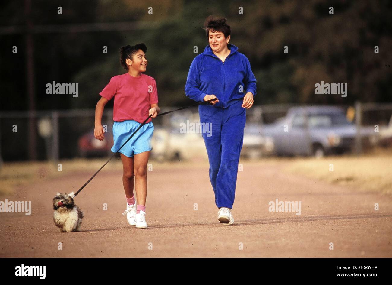 Austin Texas USA, 1991: La madre ispanica scherza con la sua figlia di 10 anni e un cane. ©1991 MR EV-105,106. ©Bob Daemmrich Foto Stock