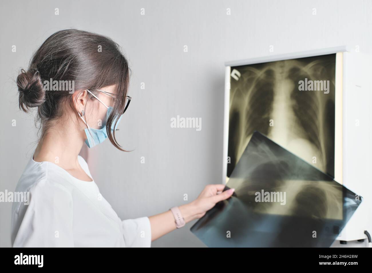 mixe race donna medico radiologo controllo film x-ray immagine dalla macchina. Analizzare un progresso della malattia. Concetto di assistenza sanitaria, diagnostica moderna met Foto Stock