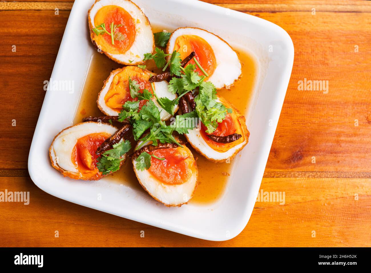 Vista dall'alto uova di pollo fritte bollite con salsa di tamarindo, condite con peperoncino secco e coriandolo. Il cibo si chiama Kai-Loog-Keay in lingua tailandese, il me Foto Stock