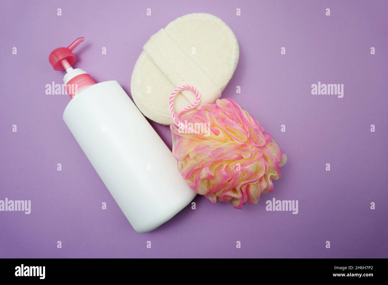 Prodotti da bagno a fondo piatto doccia bottiglia con soffio doccia e spazzola per capelli su sfondo viola Foto Stock