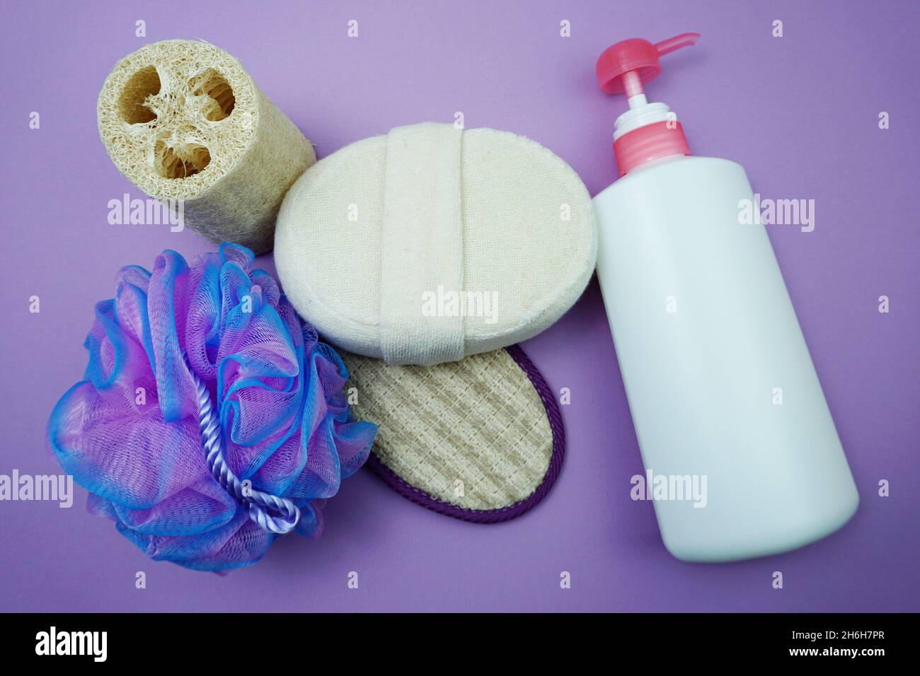 Prodotti da bagno a fondo piatto doccia bottiglia con soffio doccia e spazzola per capelli su sfondo viola Foto Stock