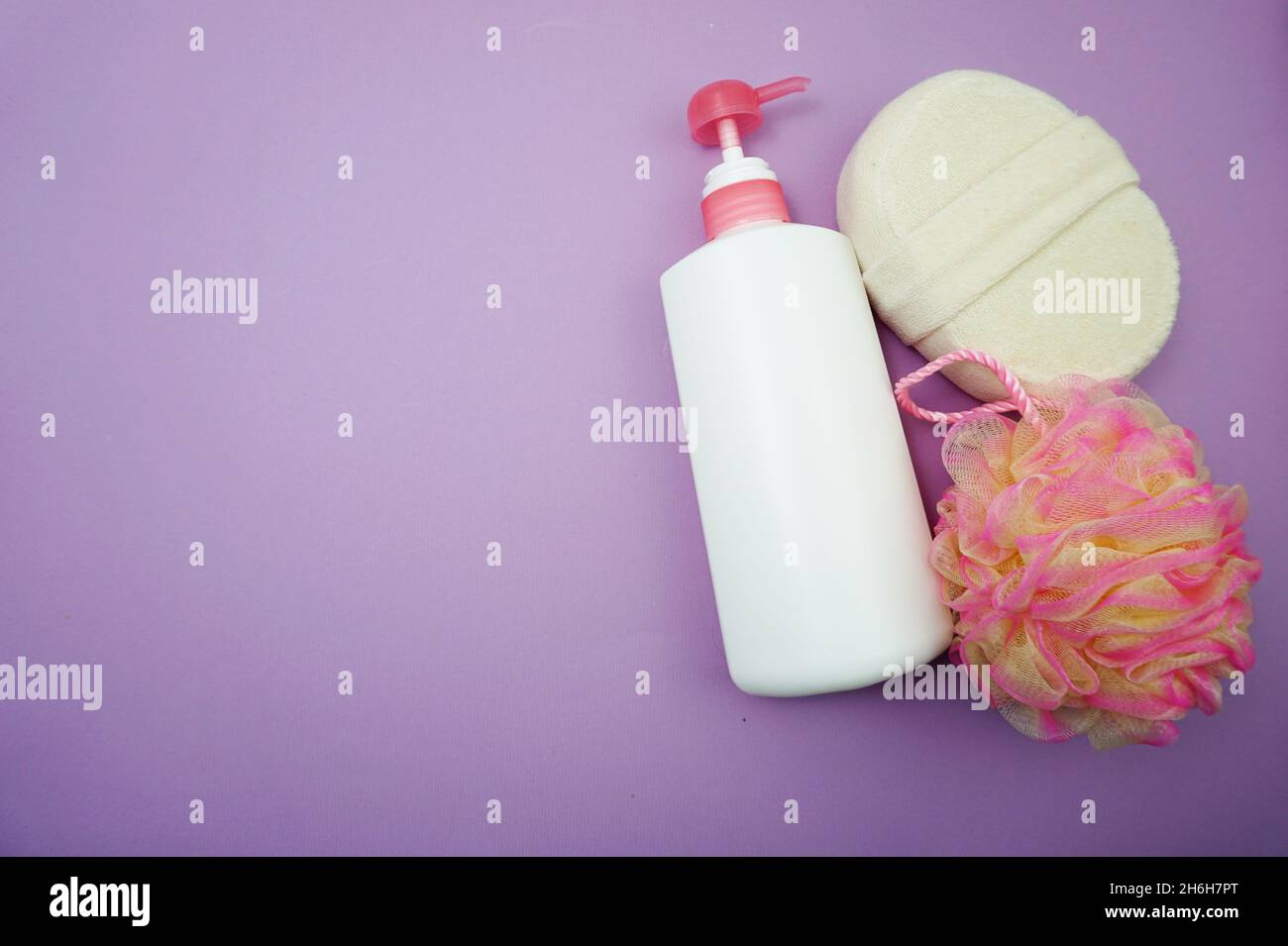 Prodotti da bagno a fondo piatto doccia bottiglia con soffio doccia e spazzola per capelli su sfondo viola Foto Stock