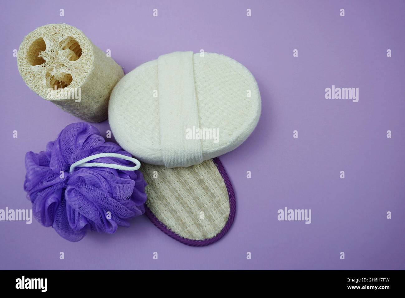Prodotti da bagno a fondo piatto doccia bottiglia con soffio doccia e spazzola per capelli su sfondo viola Foto Stock