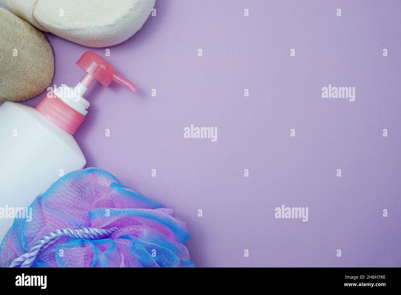 Prodotti da bagno a fondo piatto doccia bottiglia con soffio doccia e spazzola per capelli su sfondo viola Foto Stock