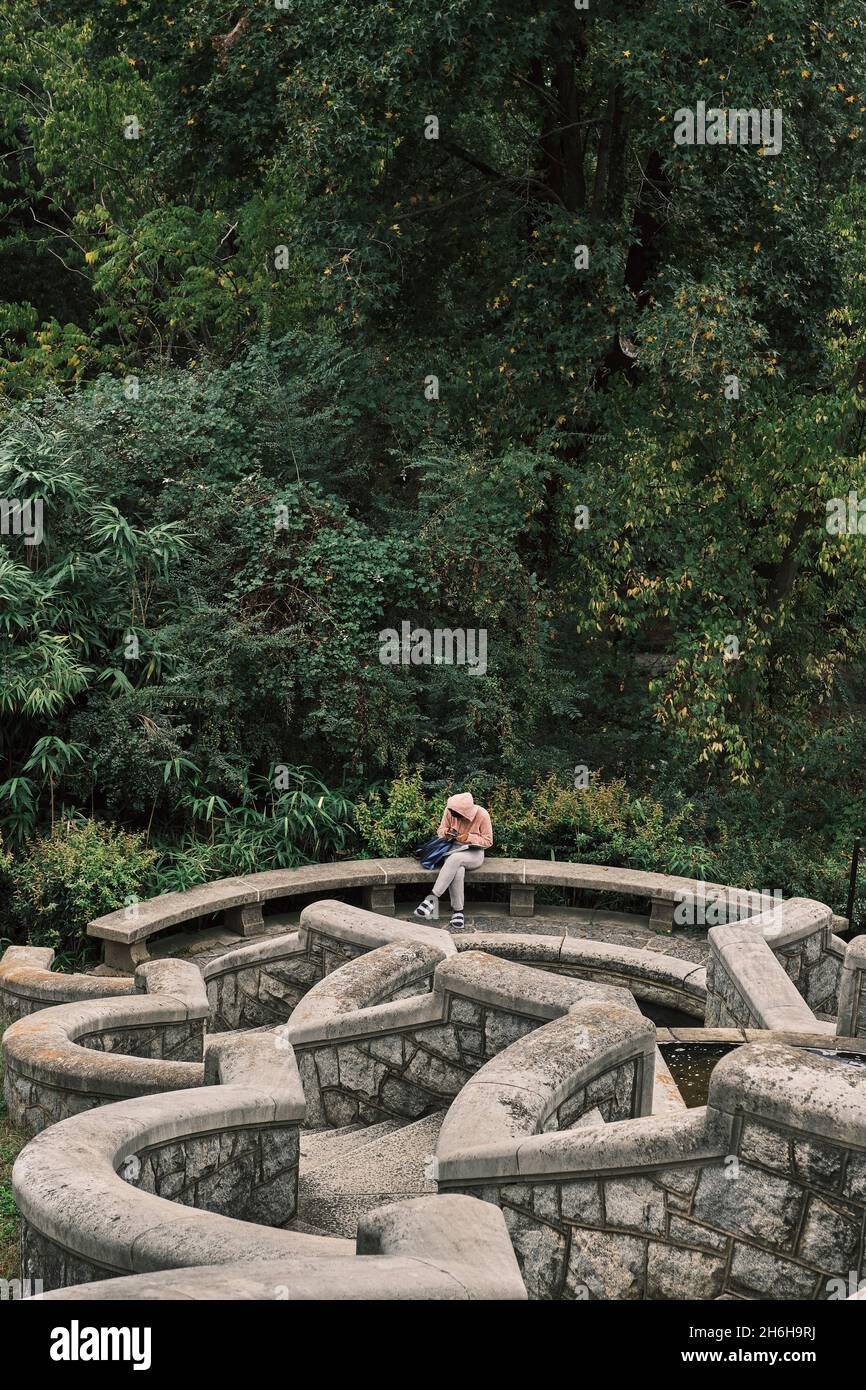 Un giovane legge nel giardino italiano geometricamente modellato della tenuta Maymont, Richmond, VA. Foto Stock