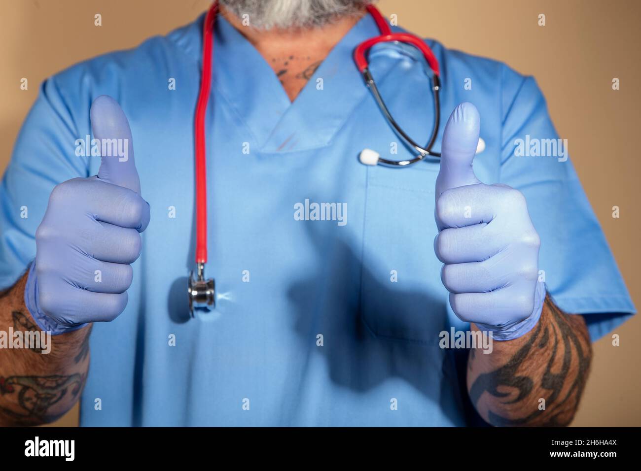 Primo piano di un medico che mostra pollici in su Foto Stock