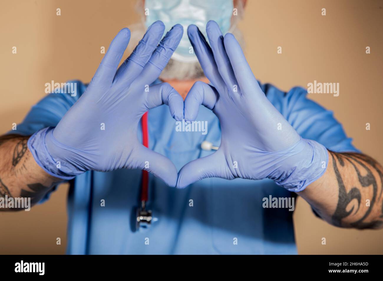 QCloseup colpo di un medico che fa una forma del cuore con le sue mani Foto Stock