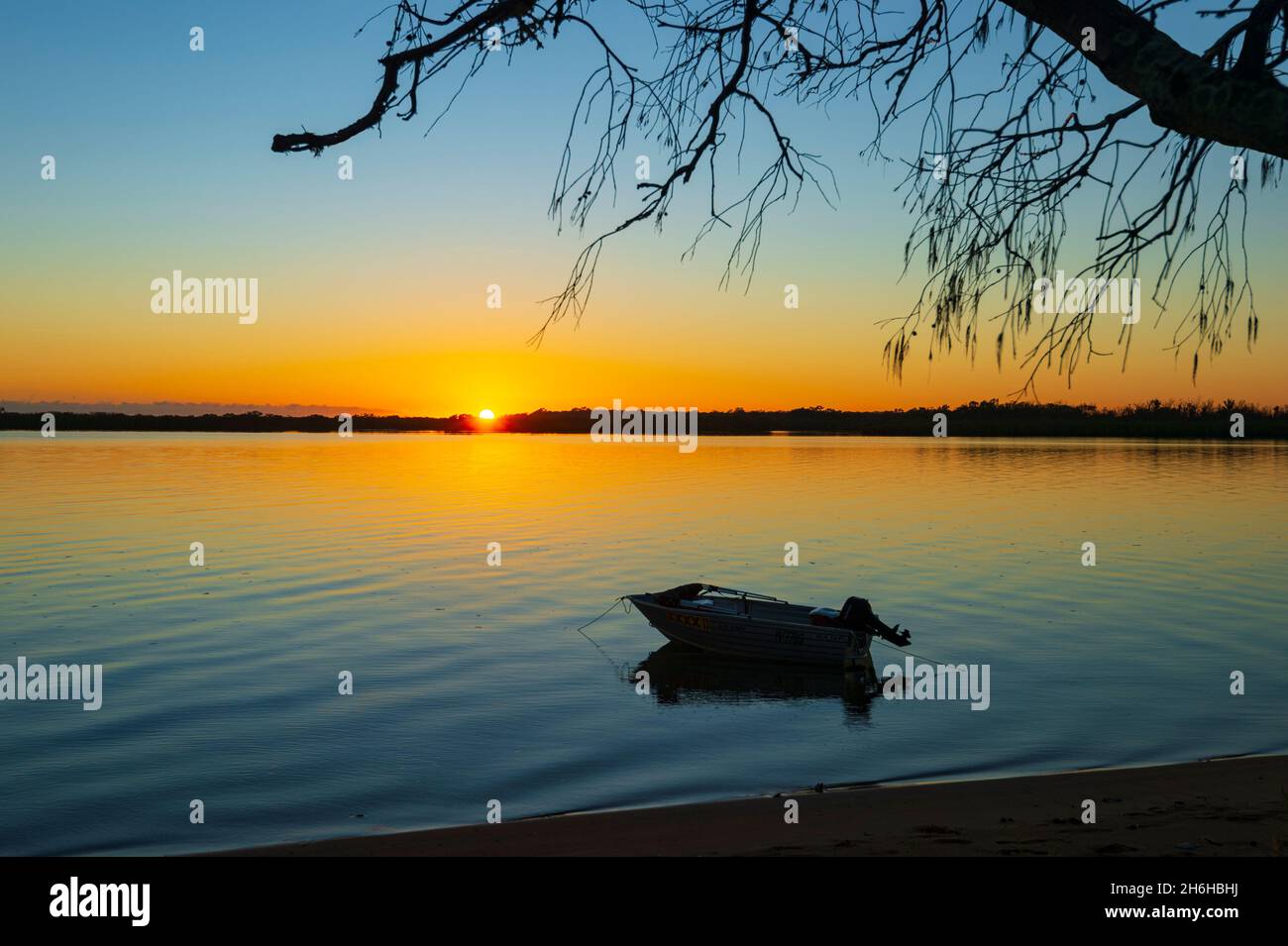 Sole all'orizzonte all'alba a Miara Beach, Queensland, QLD, Australia Foto Stock