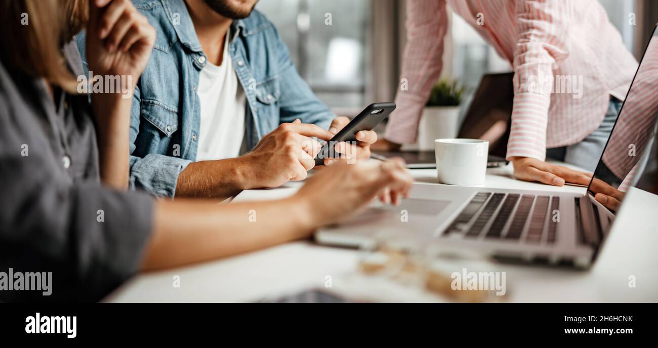 Gruppo di giovani che lavorano o studiano insieme. Hipster team in coworking. Giovani colleghi d'affari moderni. Lavoro di squadra. Concetto di avvio Foto Stock