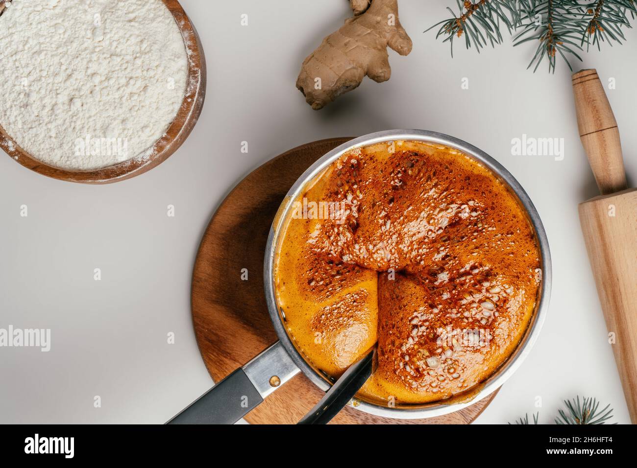 Tutorial passo-passo sulla cottura dei biscotti di pan di zenzero di Natale. Fase 6: Togliere dal fuoco e aggiungere il burro e l'uovo. Vista dall'alto Foto Stock