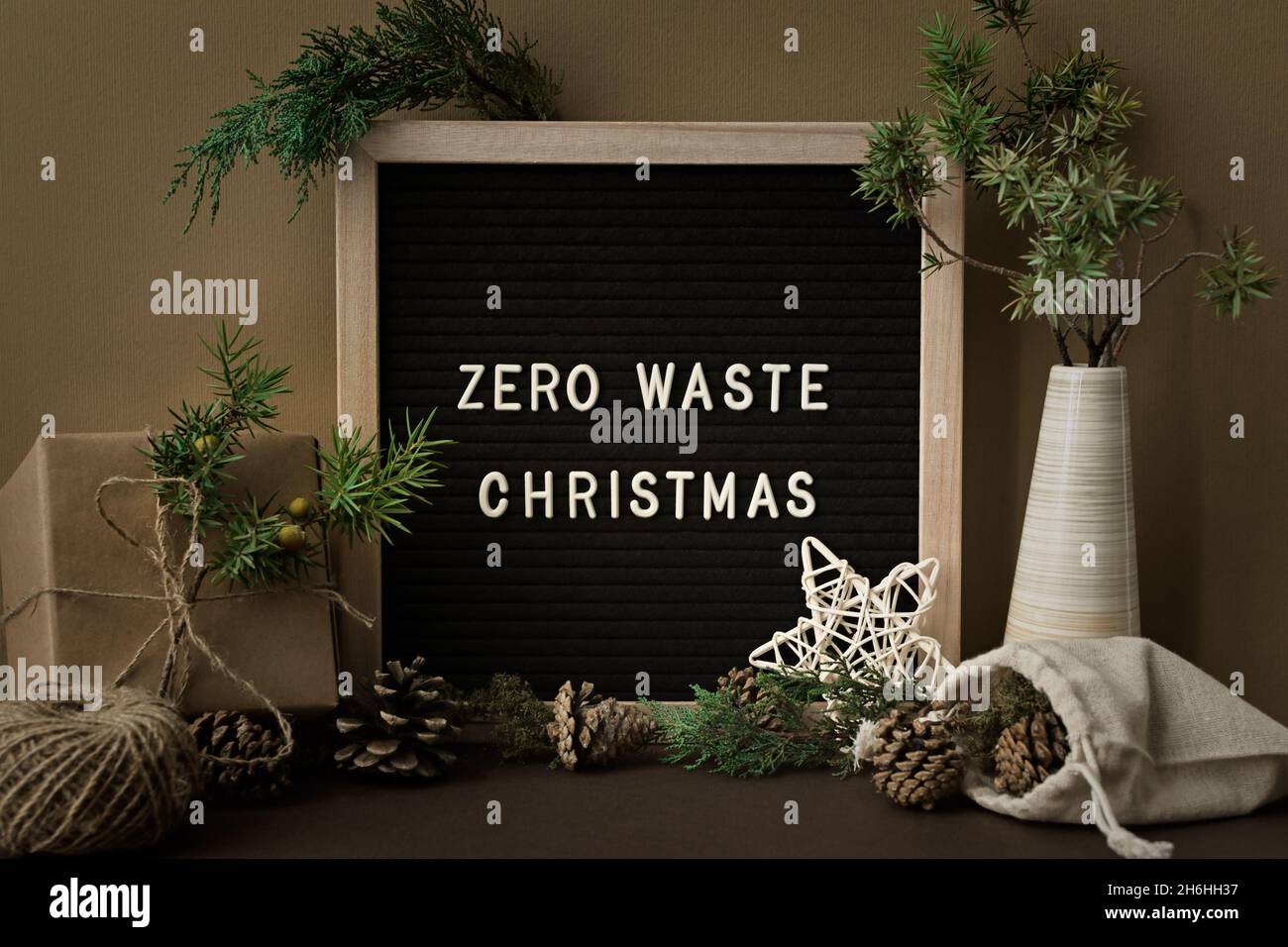 Concetto di Natale senza sprechi. Materiali naturali, legno, carta, imballaggio, coni di abete. Cornice con iscrizione. Biglietto d'auguri in eco-styl Foto Stock