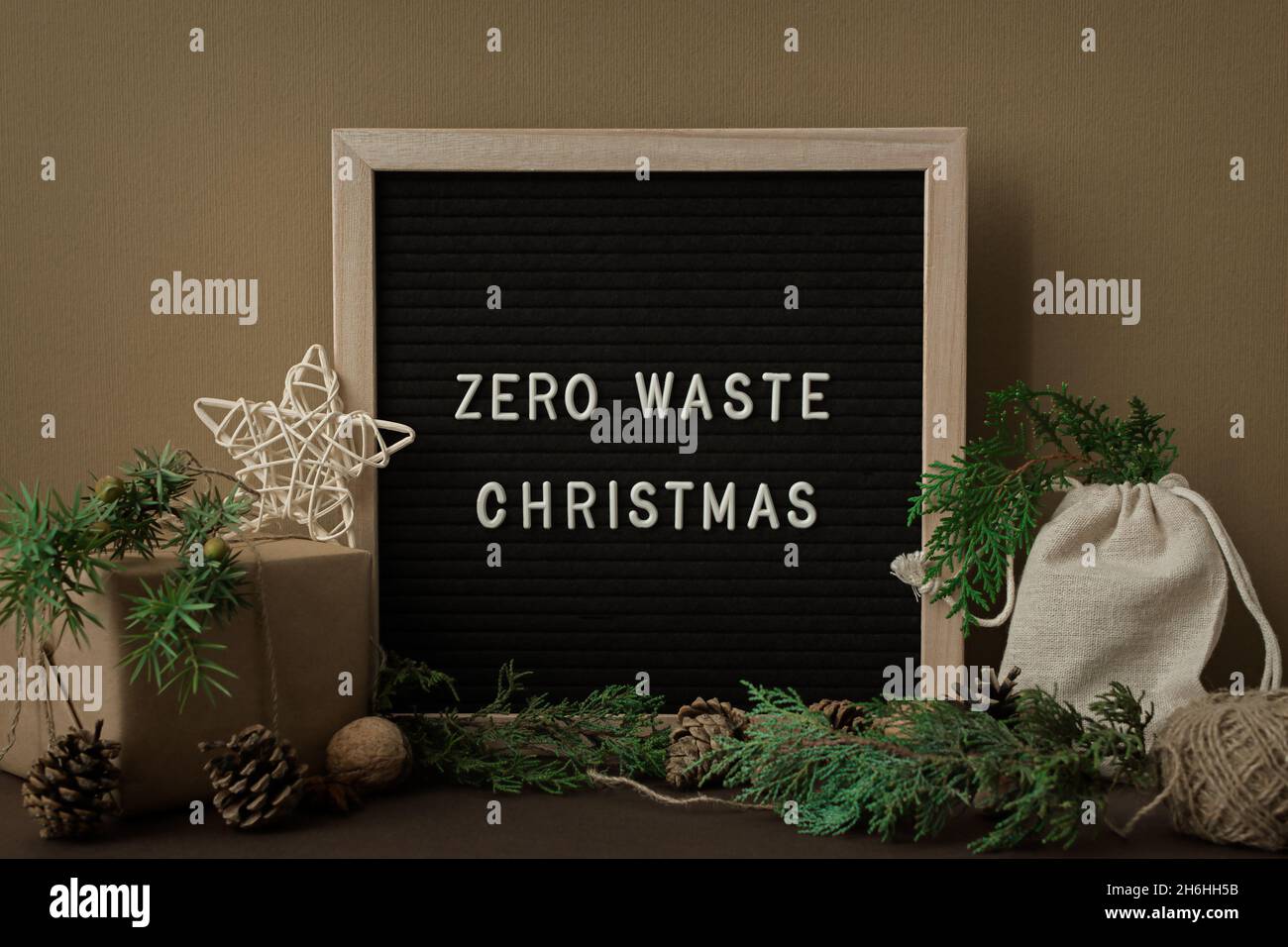 Concetto di Natale senza sprechi. Materiali naturali, legno, carta, imballaggio, coni di abete. Cornice con iscrizione. Biglietto d'auguri in eco-styl Foto Stock