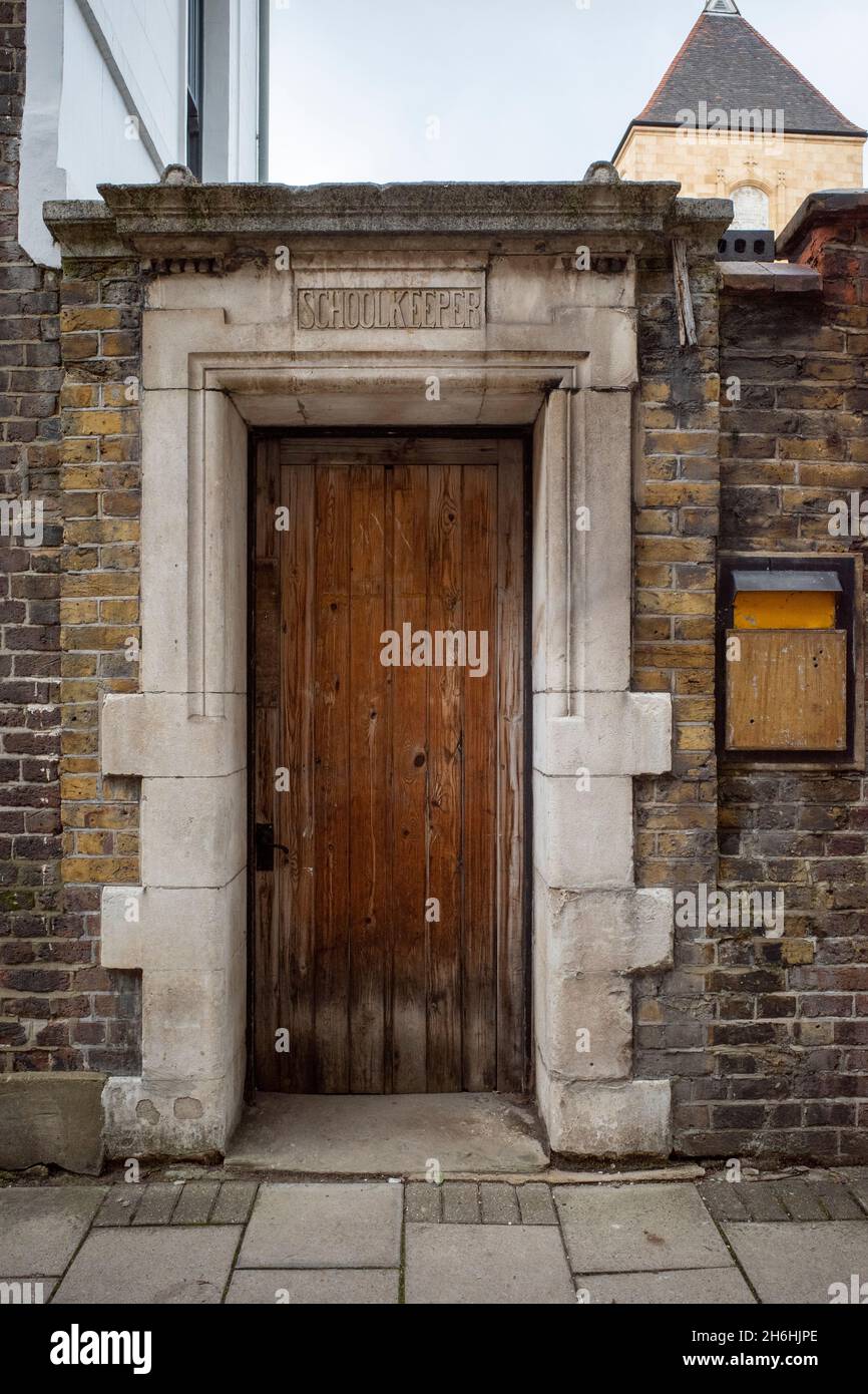 Porta vittoriana in pietra e legno per un consiglio scolastico della scuola di Londra con la leggenda School Keeper sull'architrave di Clerkenwell Foto Stock