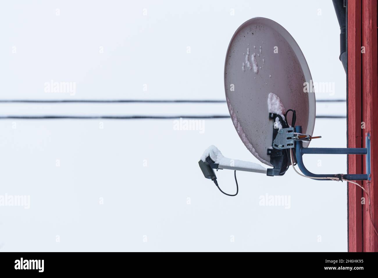 Un piatto parabolico grigio sul lato di una casa Foto Stock