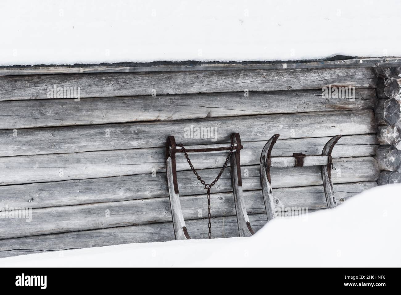 La vecchia slitta scivola contro il muro di legno Foto Stock