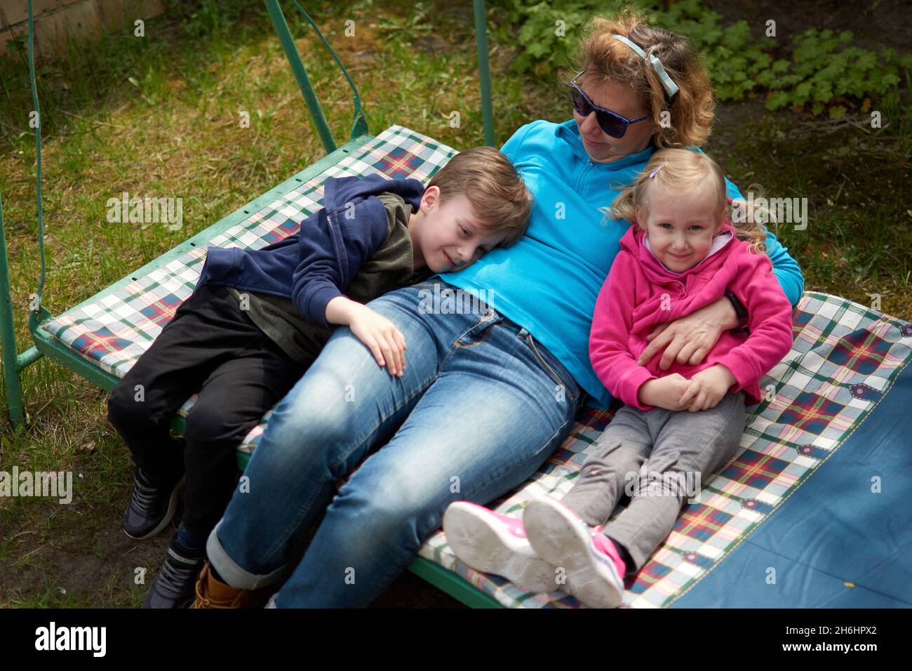 Nonna e i suoi due nipoti che si divertono in un'altalena, nonno e nipote amano la loro nonna. Outdors rilassante nella campagna della nonna hou Foto Stock