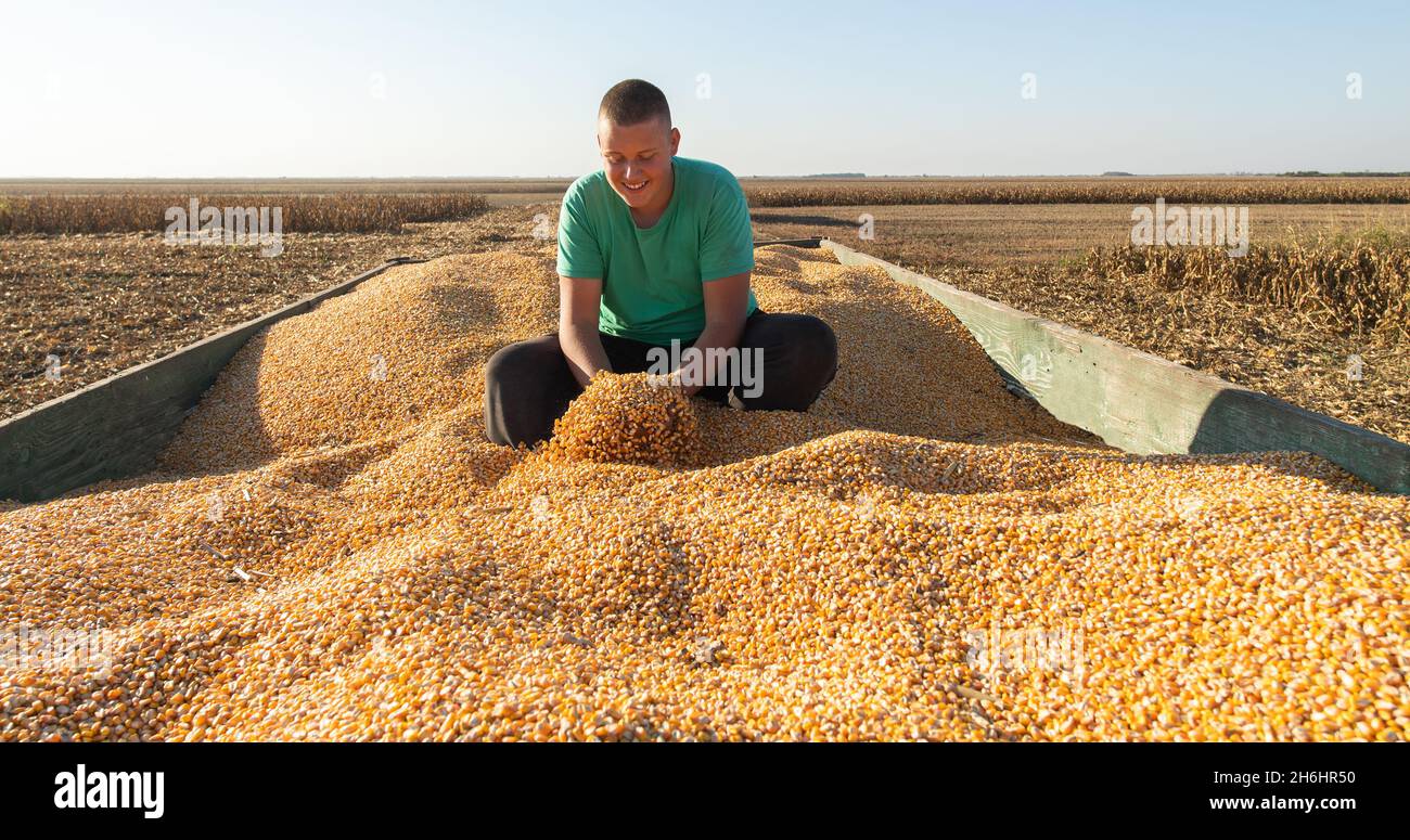 Ritratto contadino maschio con mais, uomo sorridente raccolta Foto Stock