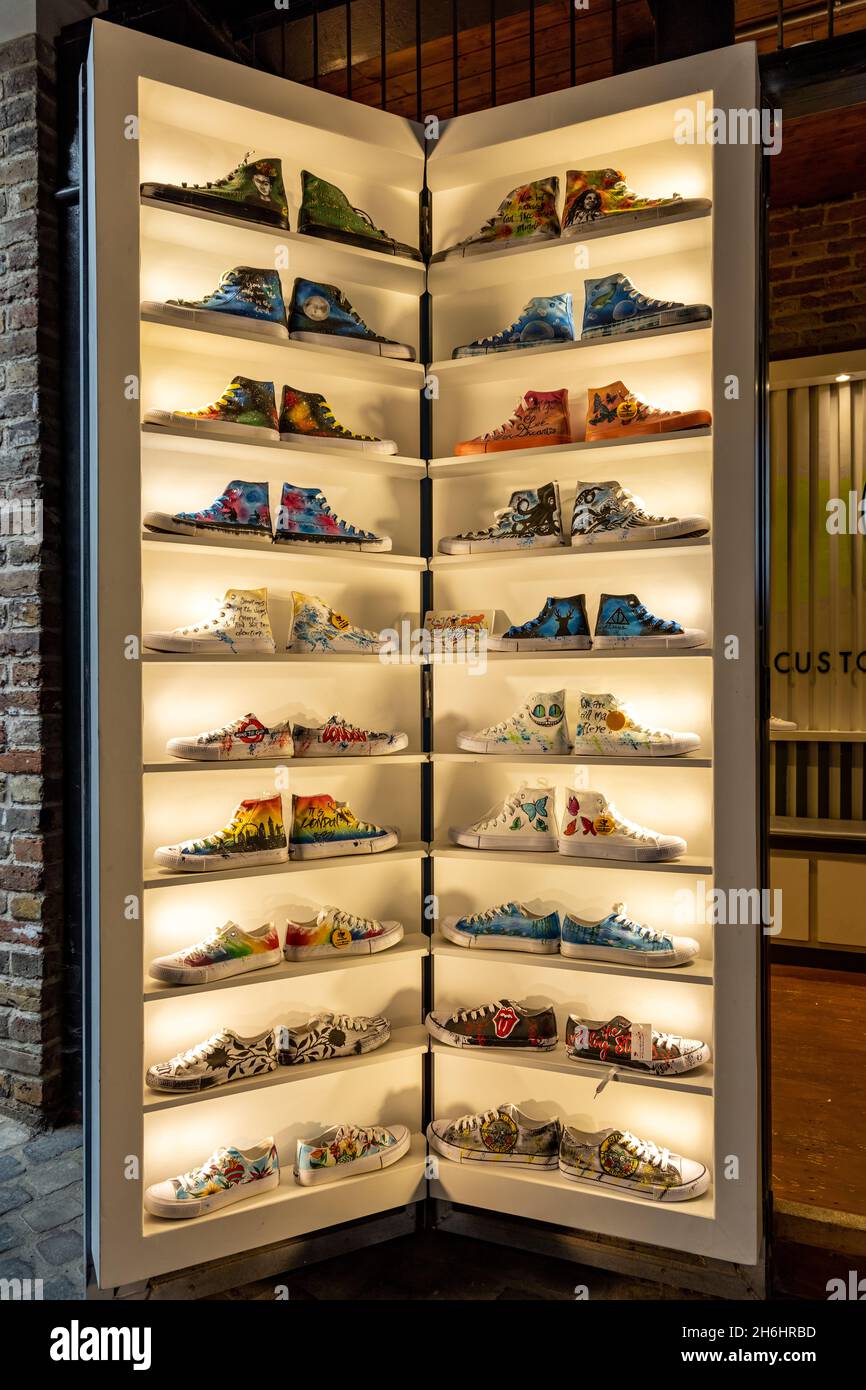 Mostra colorata di sneakers al di fuori del negozio di calzature, Camden Stables Market, Camden Town, Londra, inghilterra. Foto Stock