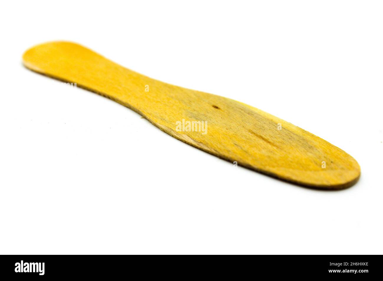 Cucchiaio di legno isolato su sfondo bianco con fuoco selettivo Foto Stock