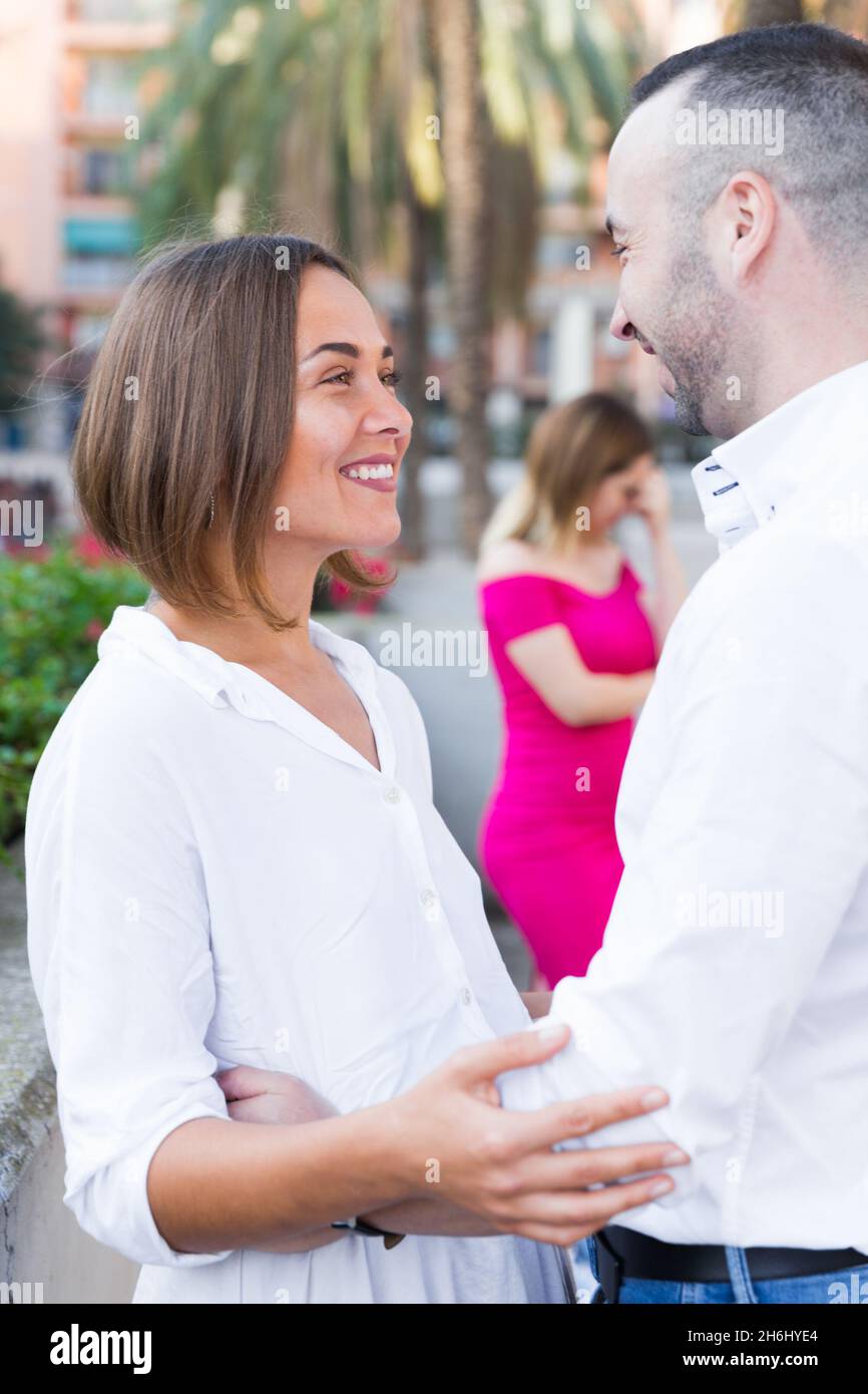 Una coppia allegra sta parlando e la donna li sta invidiando Foto Stock
