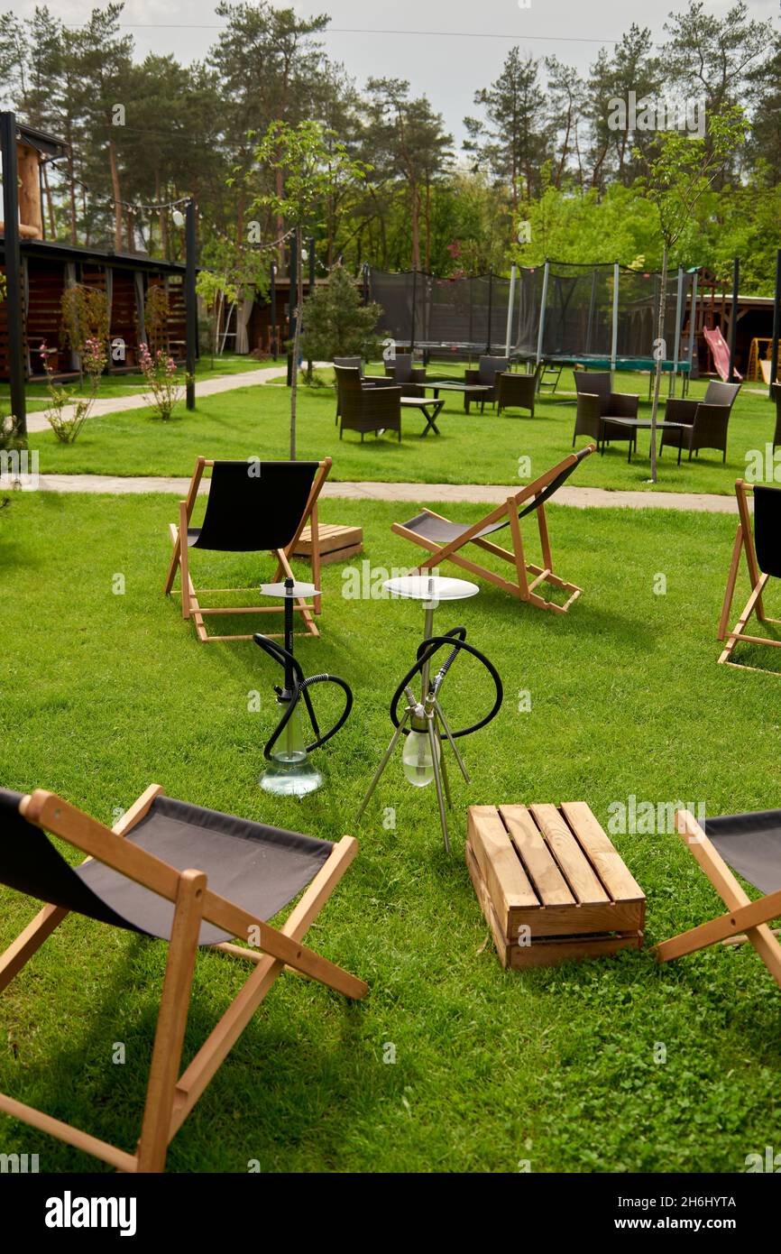 Vari hookah in natura in una calda giornata di sole. Hokah orientale fumatori, attività ricreative all'aria aperta. Sedie a sdraio su erba di geen. Il posto per le Foto Stock