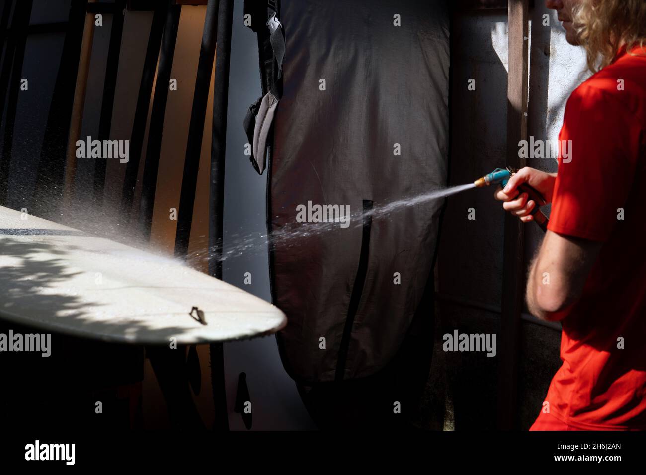 surfer washes bianco surf con acqua. bali Foto Stock