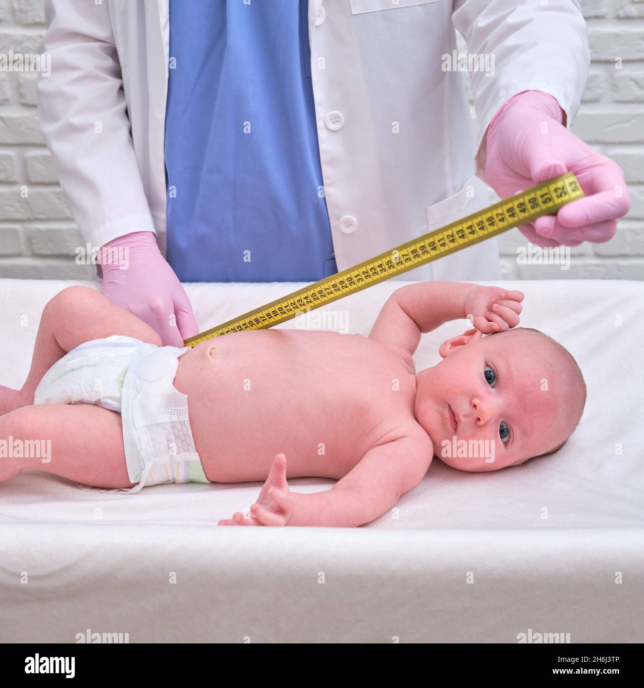 Il medico misura la crescita di un neonato. Un infermiere in uniforme  controlla la circonferenza della testa e dell'addome del bambino Foto stock  - Alamy
