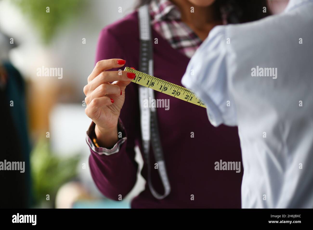 Donna fashion designer effettua misurazioni con centimetri Foto Stock